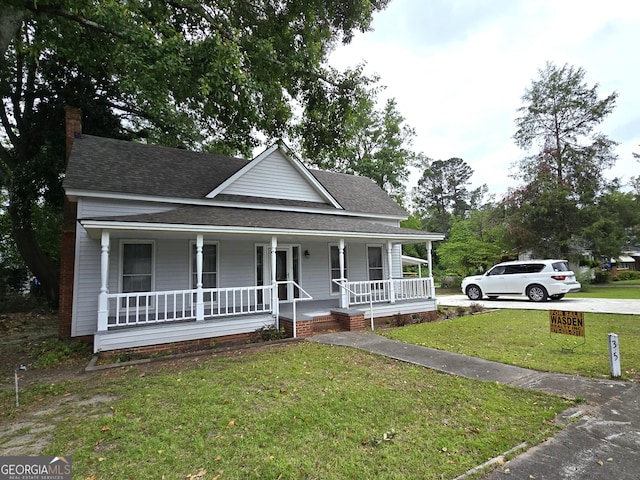 35 Cheatham St, Wadley, GA 30477 - farmhouse-style home featuring roof with shingles, a porch, a front lawn, and a chimney