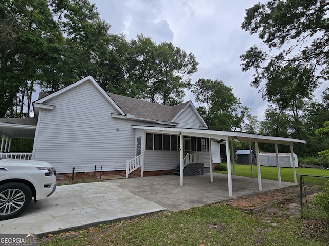 35 Cheatham St, Wadley, GA 30477 - rear view of property with roof with shingles, a sunroom, a yard, an attached carport, and entry steps