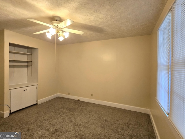 35 Cheatham St, Wadley, GA 30477 - unfurnished bedroom with a textured ceiling, dark carpet, baseboards, and ceiling fan