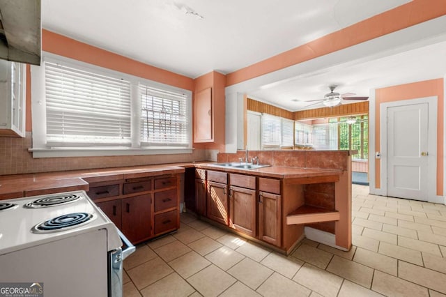 3956 Tell Rd SW, Atlanta, GA 30331 - kitchen featuring brown cabinetry, a peninsula, white range with electric stovetop, light tile patterned flooring, and open shelves