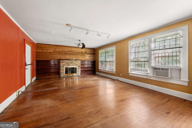 3956 Tell Rd SW, Atlanta, GA 30331 - unfurnished living room with a glass covered fireplace, wood-type flooring, cooling unit, wooden walls, and track lighting