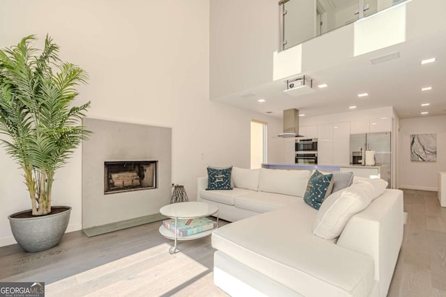 85 Lila Way, Dahlonega, GA 30533 - living room featuring light wood-type flooring, baseboards, a fireplace with raised hearth, recessed lighting, and a high ceiling