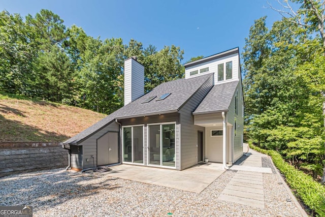 85 Lila Way, Dahlonega, GA 30533 - back of house featuring a shingled roof, a chimney, and a patio area