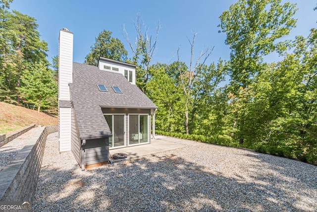 85 Lila Way, Dahlonega, GA 30533 - rear view of house featuring a shingled roof, a patio area, and a chimney