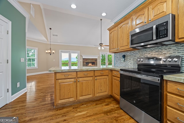 894 Oak Pointe Dr, Cleveland, GA 30528 - kitchen featuring appliances with stainless steel finishes, a peninsula, a fireplace, ceiling fan, and backsplash