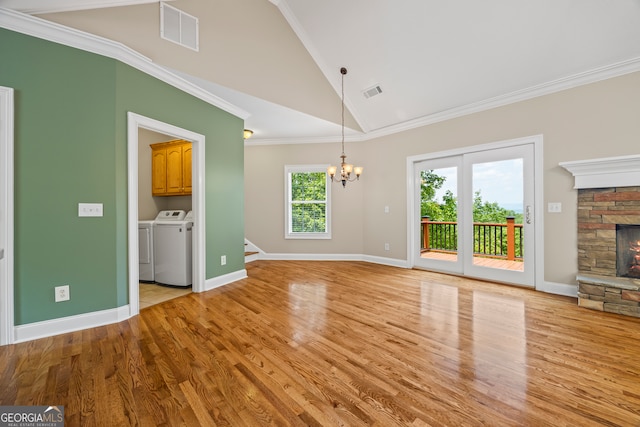 894 Oak Pointe Dr, Cleveland, GA 30528 - unfurnished living room with washer and dryer, a chandelier, a fireplace, light wood-type flooring, and baseboards