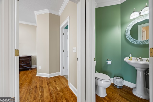 894 Oak Pointe Dr, Cleveland, GA 30528 - half bathroom featuring crown molding, wood finished floors, toilet, and baseboards