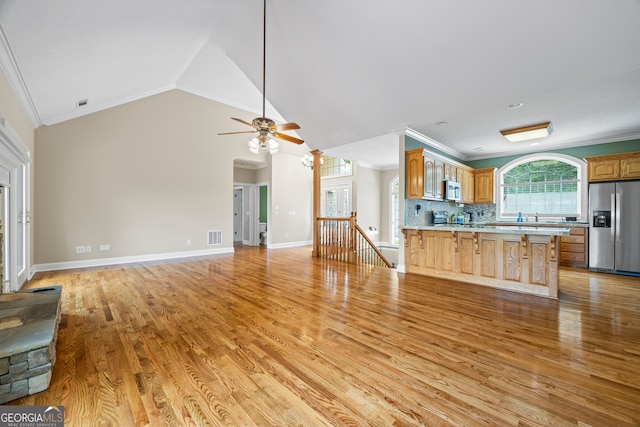 894 Oak Pointe Dr, Cleveland, GA 30528 - kitchen featuring appliances with stainless steel finishes, crown molding, a peninsula, light wood finished floors, and a kitchen bar