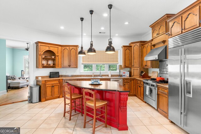353 Indigo Hills Rd, Pembroke, GA 31321 - kitchen with premium appliances, wall chimney range hood, brown cabinets, a kitchen island, and ornamental molding