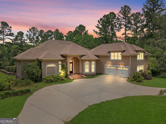 353 Indigo Hills Rd, Pembroke, GA 31321 - mediterranean / spanish-style home with stucco siding, concrete driveway, a lawn, and an attached garage