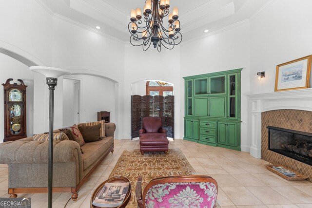 353 Indigo Hills Rd, Pembroke, GA 31321 - living area with a towering ceiling, a chandelier, light tile patterned floors, ornamental molding, and arched walkways