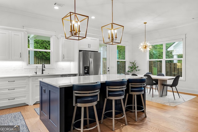 1102 Maybeck Way, Peachtree City, GA 30269 - kitchen featuring stainless steel refrigerator with ice dispenser, a sink, a center island, crown molding, and healthy amount of natural light