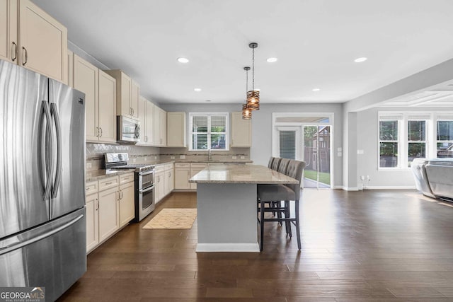 2029 Havenhurst Way, Auburn, GA 30011 - kitchen with stainless steel appliances, open floor plan, a sink, a breakfast bar, and backsplash