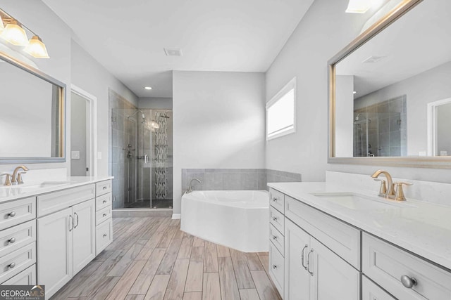 2029 Havenhurst Way, Auburn, GA 30011 - full bath with a shower stall, two vanities, a garden tub, recessed lighting, and wood finished floors