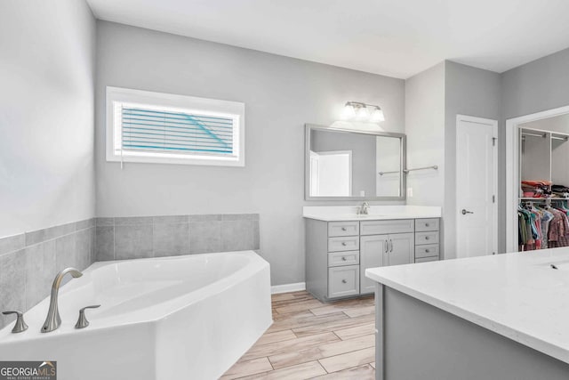 2029 Havenhurst Way, Auburn, GA 30011 - full bath featuring vanity, a bath, a walk in closet, and wood tiled floors