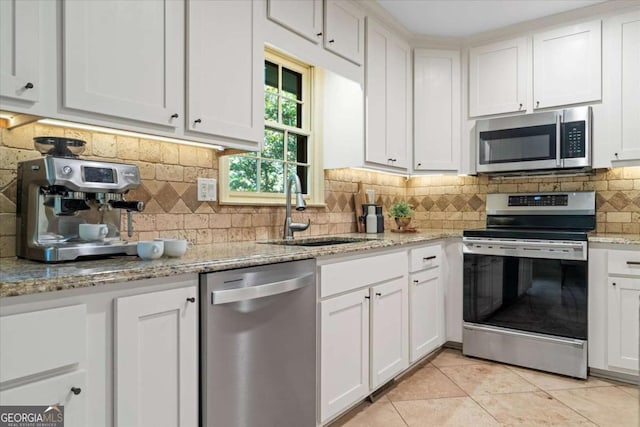 11785 Mountain Laurel Dr, Roswell, GA 30075 - kitchen with stainless steel appliances, tasteful backsplash, white cabinets, and light tile patterned flooring