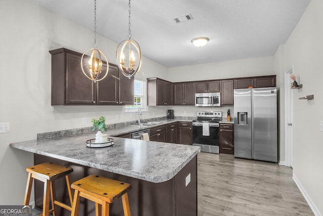 229 Wellspring Ter, Allenhurst, GA 31301 - kitchen featuring appliances with stainless steel finishes, a sink, a peninsula, dark brown cabinets, and a chandelier