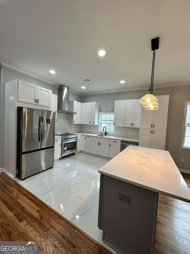 1766 W Lyle Ave, College Park, GA 30337 - kitchen featuring appliances with stainless steel finishes, wall chimney exhaust hood, a sink, crown molding, and white cabinetry