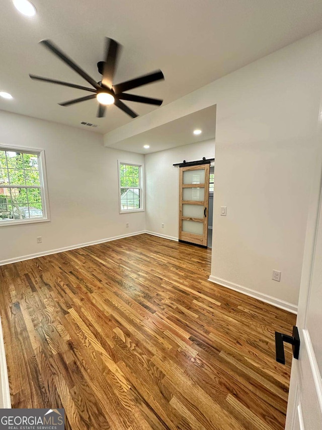 1766 W Lyle Ave, College Park, GA 30337 - empty room with a barn door, wood finished floors, ceiling fan, recessed lighting, and baseboards