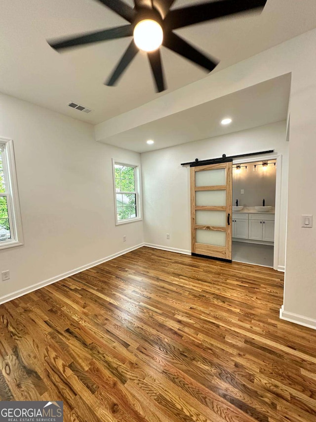 1766 W Lyle Ave, College Park, GA 30337 - unfurnished bedroom with a barn door, wood finished floors, baseboards, a sink, and recessed lighting