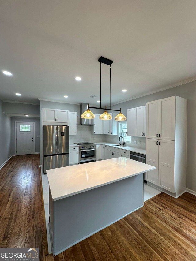 1766 W Lyle Ave, College Park, GA 30337 - kitchen with stainless steel appliances, wall chimney exhaust hood, light countertops, a kitchen island, and dark wood-type flooring