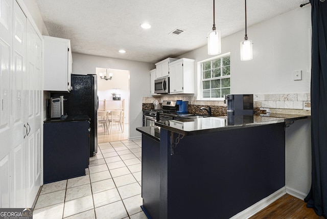 40 Briarwood Ln, Newnan, GA 30265 - kitchen with stainless steel appliances, dark countertops, decorative backsplash, white cabinetry, and a peninsula