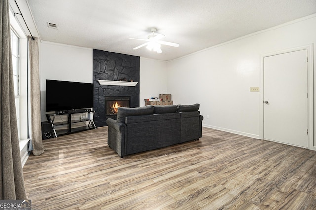 40 Briarwood Ln, Newnan, GA 30265 - living room featuring ceiling fan, wood finished floors, crown molding, and a stone fireplace