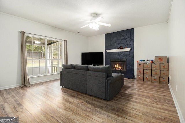 40 Briarwood Ln, Newnan, GA 30265 - living area featuring wood finished floors, crown molding, a large fireplace, ceiling fan, and baseboards