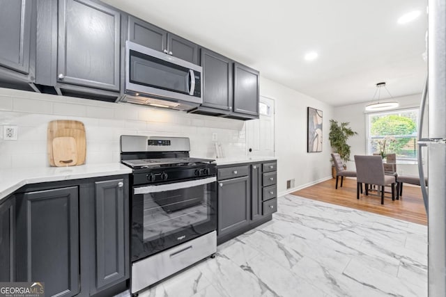 801 N Evelyn Pl NW, Atlanta, GA 30318 - kitchen featuring appliances with stainless steel finishes, light countertops, light marble finish floors, and backsplash