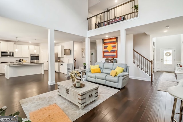 2031 Broadmoor Way, Fairburn, GA 30213 - living room featuring dark wood finished floors, stairs, a high ceiling, and recessed lighting