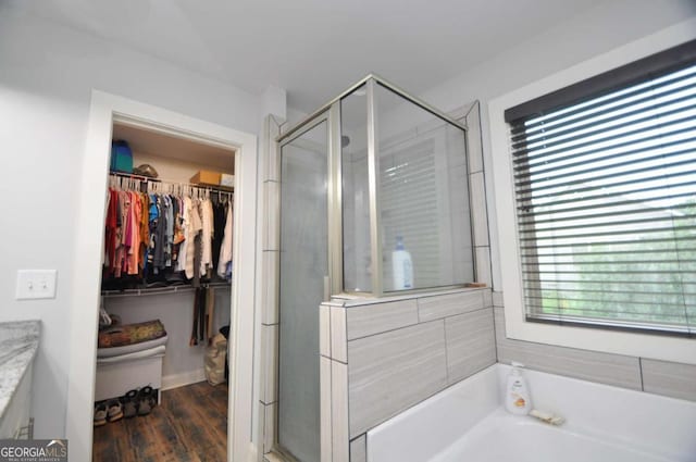 1040 Matthew Ln, Madison, GA 30650 - full bathroom featuring a shower stall, a garden tub, a walk in closet, vanity, and wood finished floors