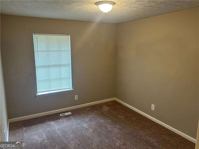 3674 Riverchase Ter, Decatur, GA 30034 - spare room featuring dark colored carpet, a textured ceiling, and baseboards