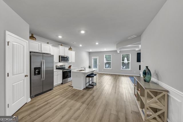 2037 Cedar Grove Rd, Conley, GA 30288 - kitchen featuring appliances with stainless steel finishes, open floor plan, white cabinetry, a kitchen bar, and recessed lighting