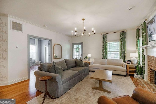 1901 Franklin Grove Pkwy, Bogart, GA 30622 - living room featuring a brick fireplace, a chandelier, light wood-type flooring, ornamental molding, and baseboards