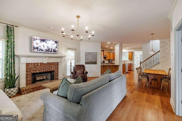 1901 Franklin Grove Pkwy, Bogart, GA 30622 - living area featuring stairs, a chandelier, light wood-style floors, a fireplace, and crown molding