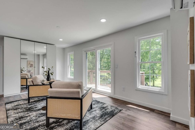 14440 Cogburn Rd, Alpharetta, GA 30004 - living room featuring healthy amount of natural light, wood finished floors, a wall mounted air conditioner, baseboards, and recessed lighting