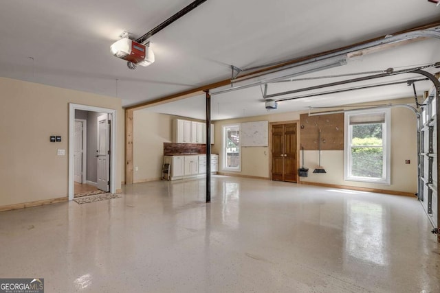 14440 Cogburn Rd, Alpharetta, GA 30004 - garage with a garage door opener and baseboards
