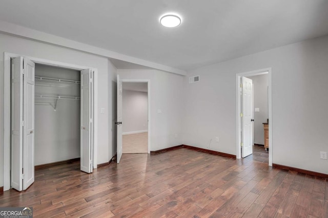 14440 Cogburn Rd, Alpharetta, GA 30004 - unfurnished bedroom with wood finished floors, baseboards, and a closet