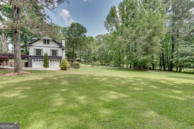 14440 Cogburn Rd, Alpharetta, GA 30004 - view of grassy yard featuring a garage and view of wooded area