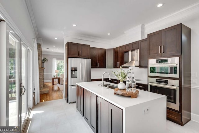 14440 Cogburn Rd, Alpharetta, GA 30004 - kitchen featuring stainless steel appliances, wall chimney exhaust hood, a sink, light countertops, and crown molding