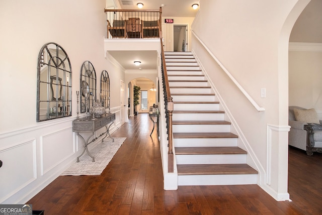 817 Nevis Way, Mcdonough, GA 30253 - staircase featuring arched walkways, crown molding, hardwood / wood-style flooring, and wainscoting