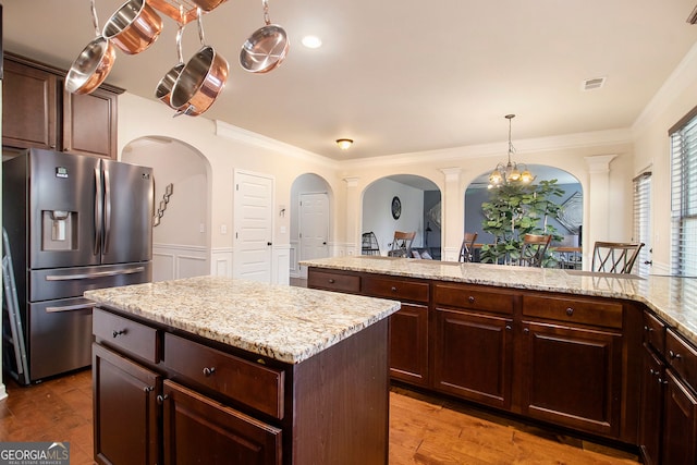 817 Nevis Way, Mcdonough, GA 30253 - kitchen featuring stainless steel fridge, arched walkways, a center island, wainscoting, and ornamental molding