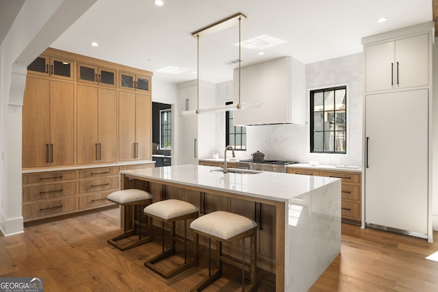 555 Orme Cir NE, Atlanta, GA 30306 - kitchen featuring a sink, a kitchen island with sink, light wood-style floors, modern cabinets, and a breakfast bar