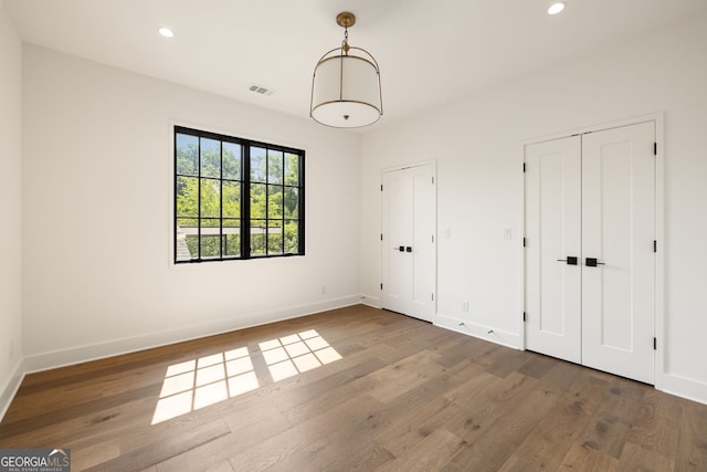 555 Orme Cir NE, Atlanta, GA 30306 - unfurnished bedroom with multiple closets, wood finished floors, baseboards, and recessed lighting