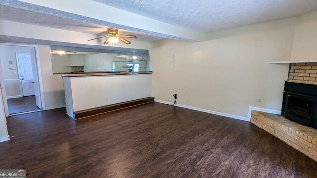 2015 Corners Cir, Lithonia, GA 30058 - unfurnished living room featuring wood finished floors, a ceiling fan, a textured ceiling, and a brick fireplace