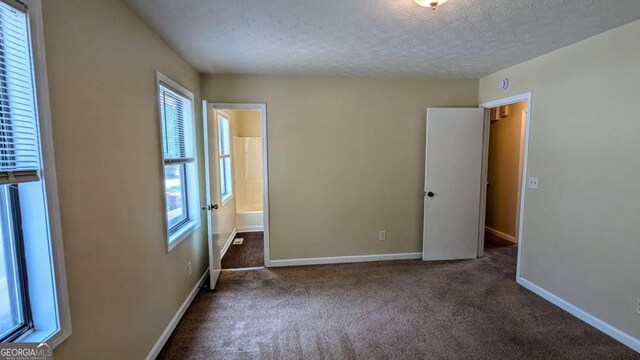 2015 Corners Cir, Lithonia, GA 30058 - unfurnished bedroom with carpet, a textured ceiling, and connected bathroom