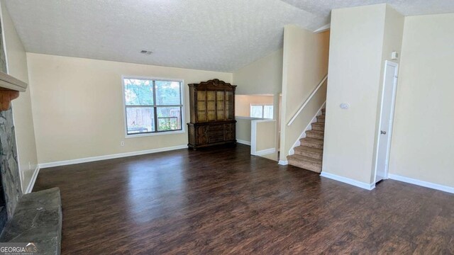 2015 Corners Cir, Lithonia, GA 30058 - unfurnished living room with a fireplace, wood finished floors, a textured ceiling, stairway, and vaulted ceiling