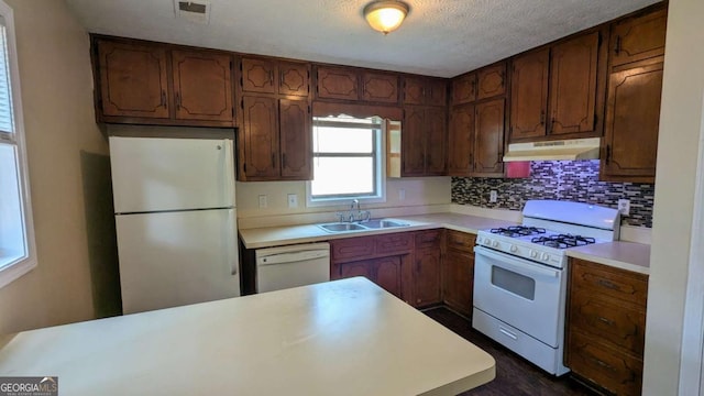 2015 Corners Cir, Lithonia, GA 30058 - kitchen with white appliances, under cabinet range hood, light countertops, decorative backsplash, and a textured ceiling