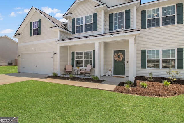26 NE Sunflower Cir, Ludowici, GA 31316 - view of front facade featuring a porch, concrete driveway, a garage, and a front lawn