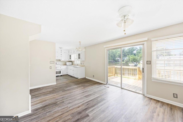 437 Edgewater Cir, Macon, GA 31220 - unfurnished living room with baseboards, a chandelier, wood finished floors, and ceiling fan